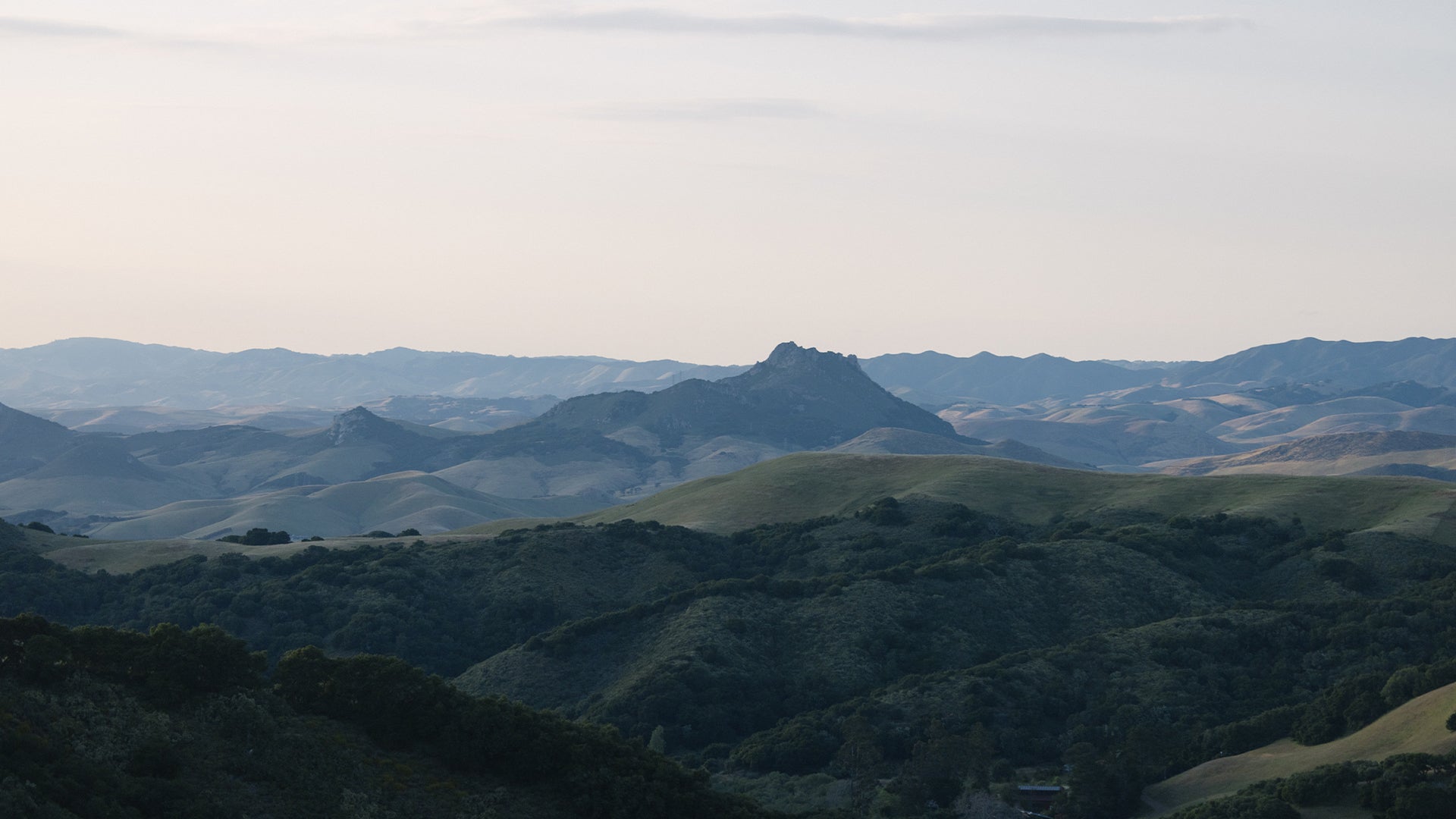 Rolling hills and mountain peaks along California's Central Coast near San Luis Obispo under a clear evening sky