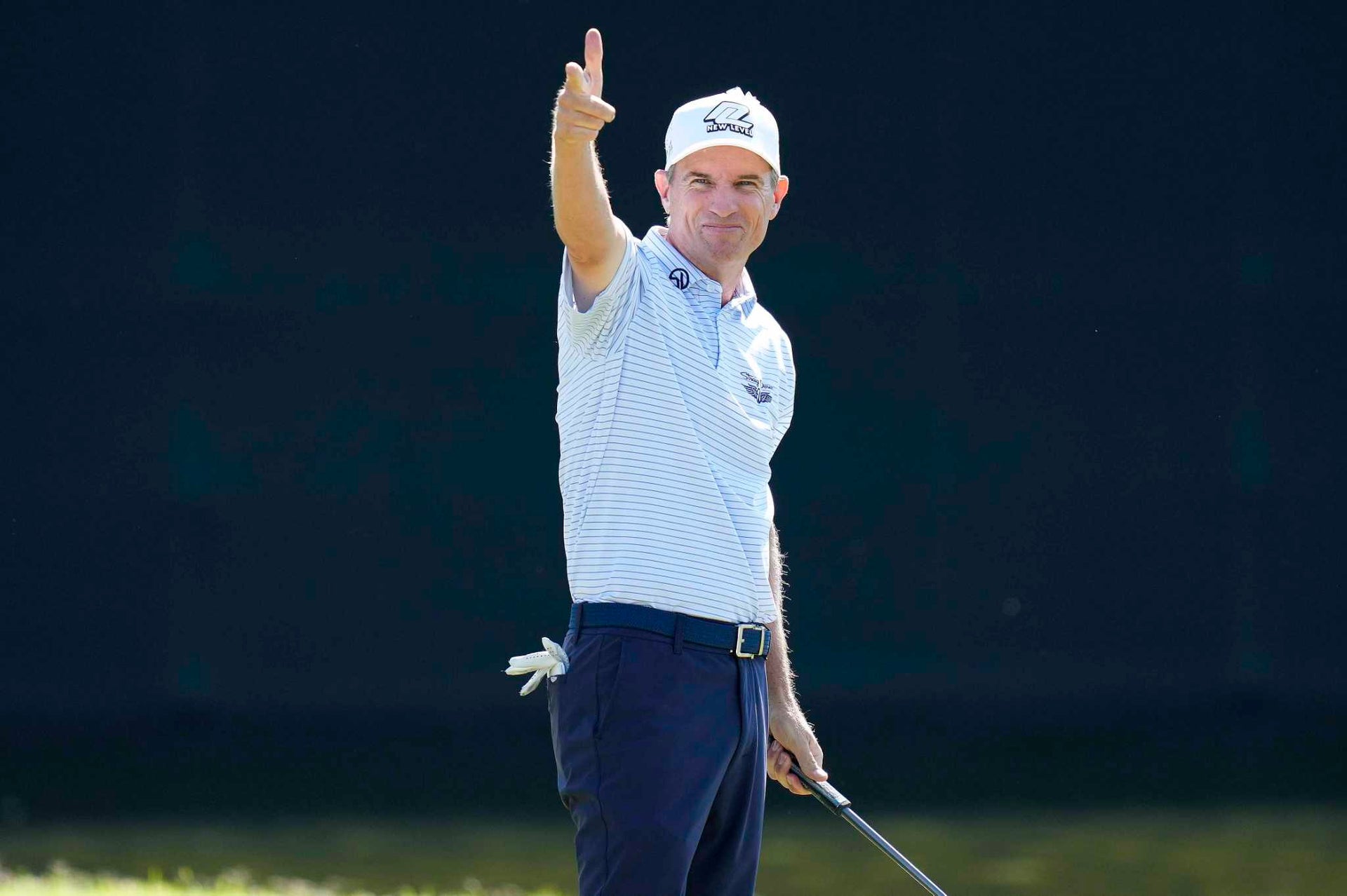 Steven Alker points to the crowd with a smile after holing a putt, wearing a Straight Down striped polo at the Charles Schwab Cup Championship.