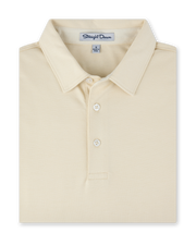 Close-up of the Oxford Polo in Summer Sand, featuring a classic collar, two-button placket, and subtle textured fabric.