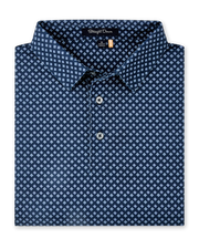 Folded Banksville Polo in New Indigo, featuring a repeating light blue geometric print, self collar, and button placket.