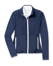 Women's Hera Jacket in New Indigo, flat lay front view featuring a hybrid construction with a quilted diamond-pattern navy front body and solid navy stretch sleeves, full zip white closure, stand-up collar, and zip side pockets with white contrast trim, layered over a white collared shirt