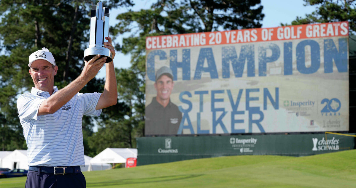 Steven Alker, wearing a Straight Down polo, raises the Insperity Invitational trophy overhead in front of a championship scoreboard displaying his name at the Insperity Invitational on PGA Tour Champions.