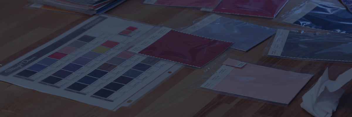 Straight Down color swatches and fabric samples spread across a design table during the apparel development process.