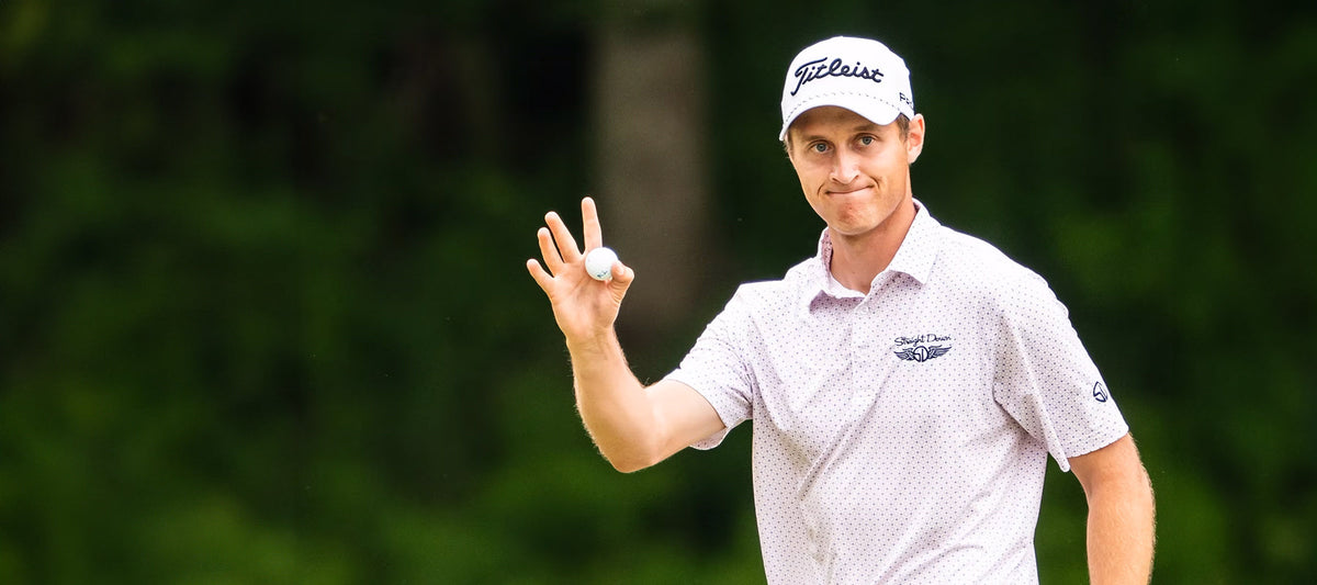 Tim Widing acknowledges the crowd with a wave and a smile, holding his ball after a strong round at Pinehurst, wearing a Straight Down printed polo