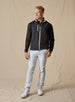 Men's Denver Vest in Black, full length model view featuring a black shell with light gray contrast full-zip closure, layered over a black long sleeve pullover, styled with light gray pants and white shoes