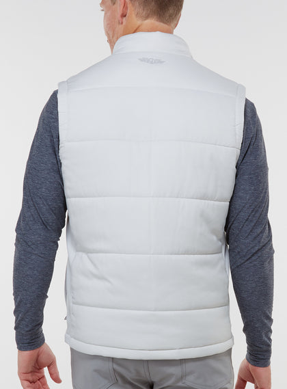 Men's Canyon Vest in Silver, back on-model view featuring a light gray quilted puffer vest with an embroidered Straight Down logo at the yoke, styled with a charcoal heather long sleeve and gray pants