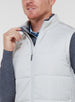 Men's Canyon Vest in Silver, side on-model view featuring a light gray quilted puffer vest with a full zip closure and front zip pocket, styled with a charcoal heather long sleeve, gray pants, and dark shoes