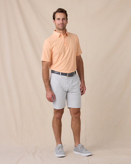 Dodge Polo in Cantalope Orange, full-body lifestyle model view styled with silver shorts