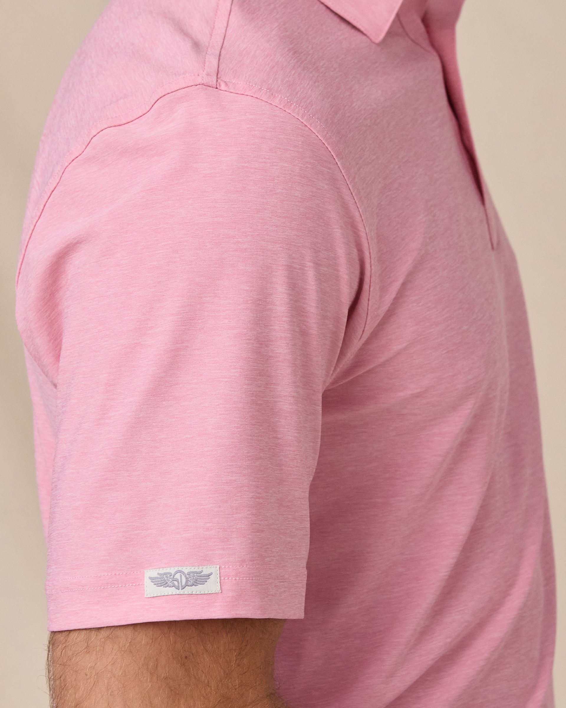 Close-up sleeve detail of Dodge Polo in Pink with woven logo tab