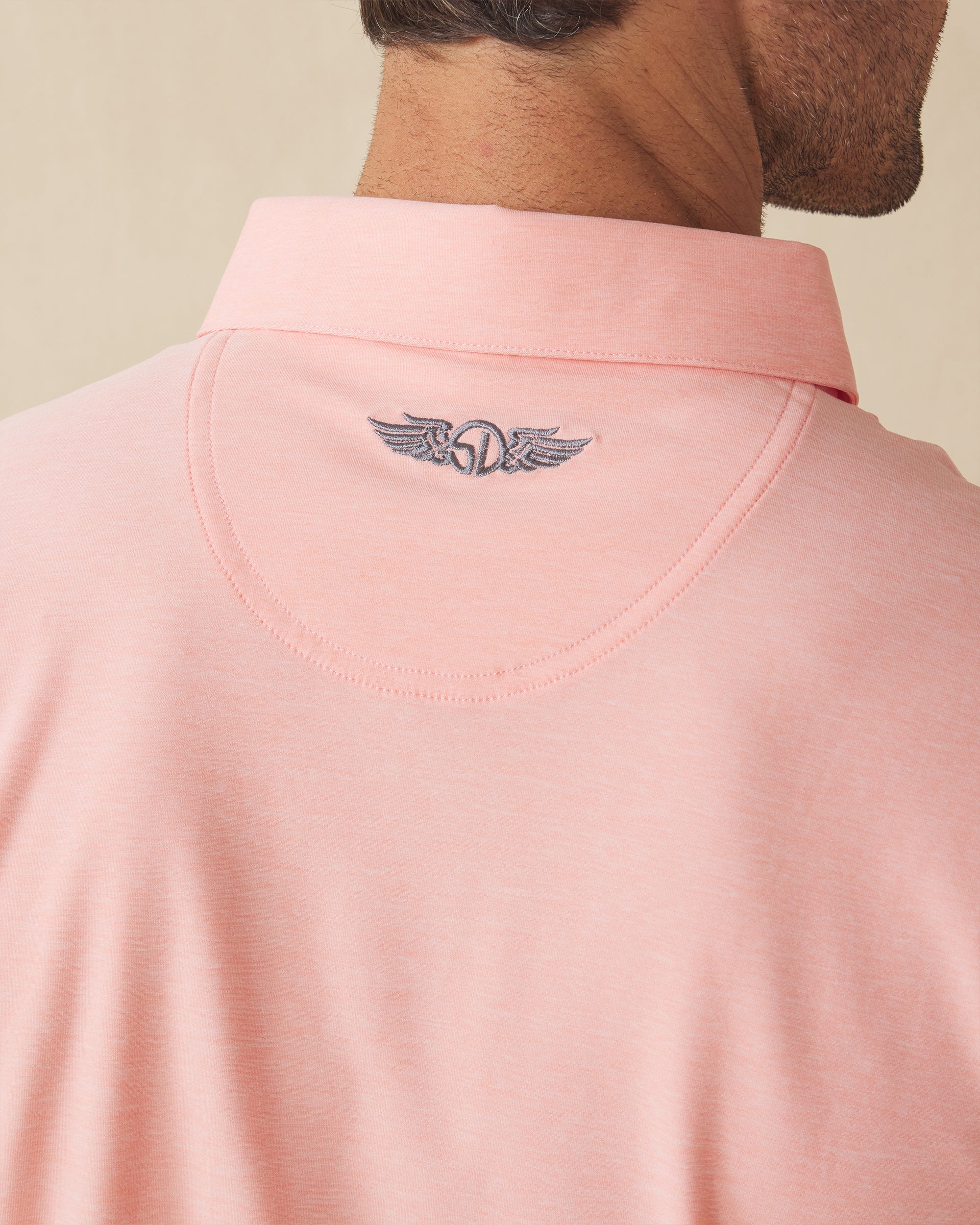 Close-up back detail of Dodge Polo in Spritz Orange with embroidered neck logo