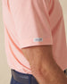 Close-up sleeve detail of Dodge Polo in Spritz Orange with woven logo tab