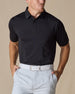Men’s Olympic Polo in Black, front view worn with light golf pants