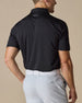 Men’s Olympic Polo in Black, back view worn with light golf pants