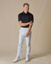 Men’s Olympic Polo in Black, full-body styling view with light golf pants and white golf shoes