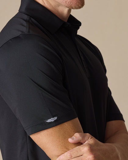 Men’s Olympic Polo in Black, close-up sleeve detail with embroidered logo