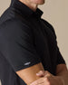 Men’s Olympic Polo in Black, close-up sleeve detail with embroidered logo
