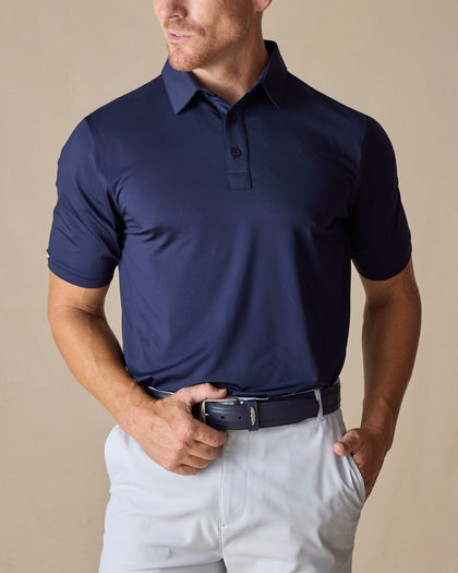Men’s Olympic Polo in Indigo Blue, front view worn with light golf pants