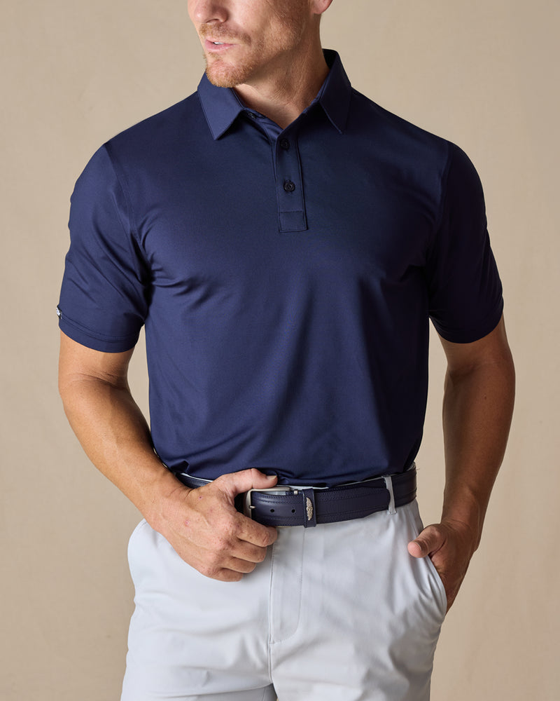 Men’s Olympic Polo in Indigo Blue, front view worn with light golf pants