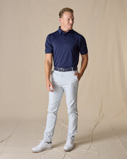 Men’s Olympic Polo in Indigo Blue, full-body styling view with light golf pants and white golf shoes