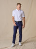 Men’s Olympic Polo in White, full-body styling view with navy golf pants and white golf shoes