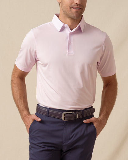 Men’s solid lilac polo with short sleeves and button placket, paired with navy shorts
