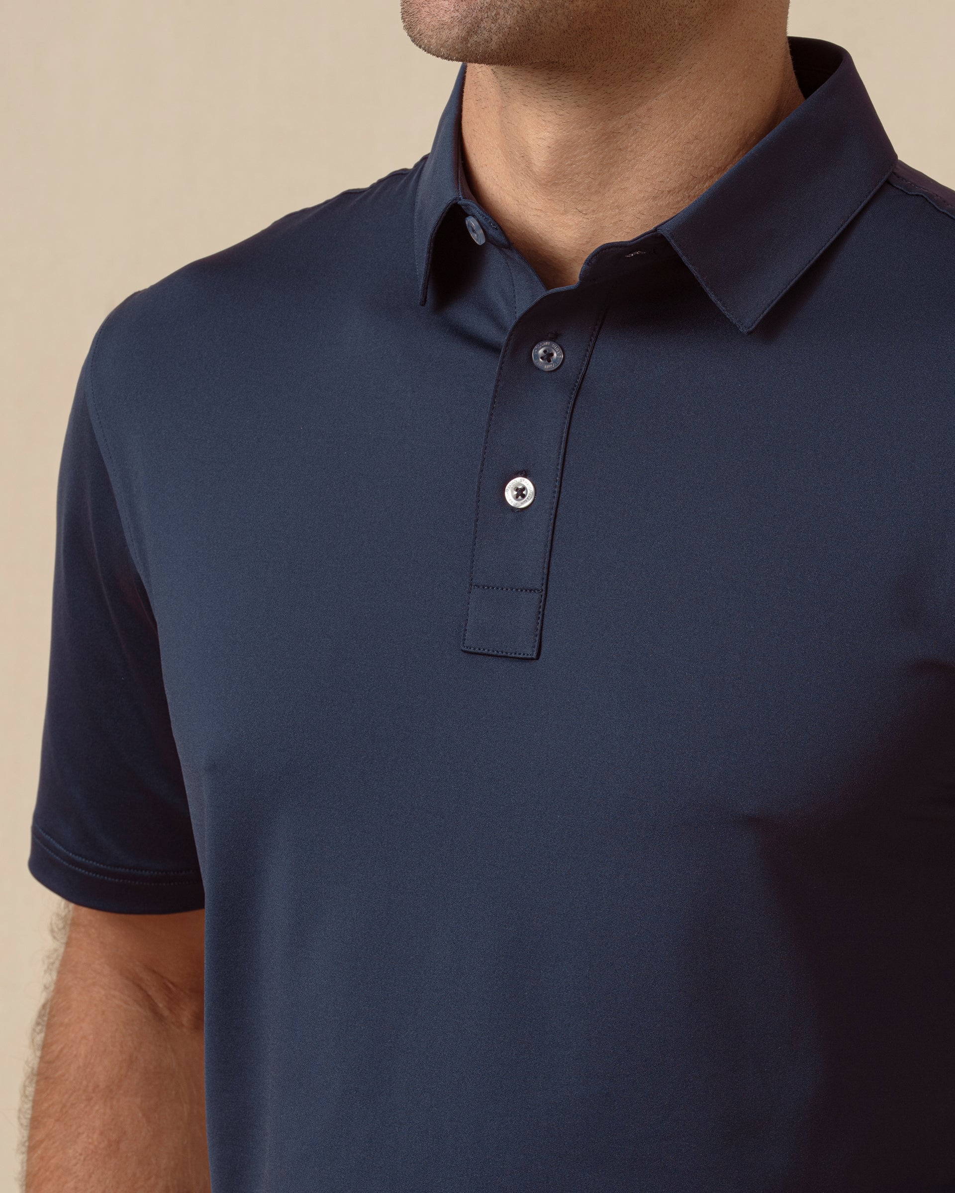 Close-up of men’s blue polo collar and button placket with clean, minimal design
