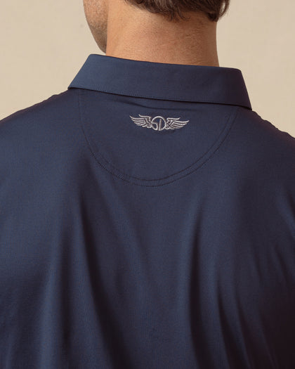 Close-up of men’s blue polo sleeve showing smooth fabric and logo tab detail