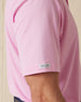 Close-up of men’s pink polo sleeve showing smooth fabric and logo tab detail