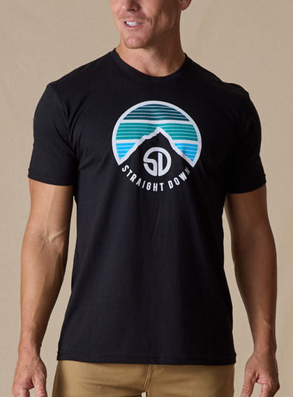Straight Down Landscape Tee in Black, on model front view showing black crew neck with circular mountain graphic paired with tan pants