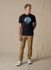 Straight Down Landscape Tee in Black, on model full length view showing black crew neck with mountain graphic paired with tan pants and white golf shoes