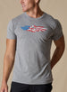 Men's USA Wings Tee in Heather, on model front view featuring a heather gray crewneck with an American flag Straight Down logo graphic on the chest styled with black pants