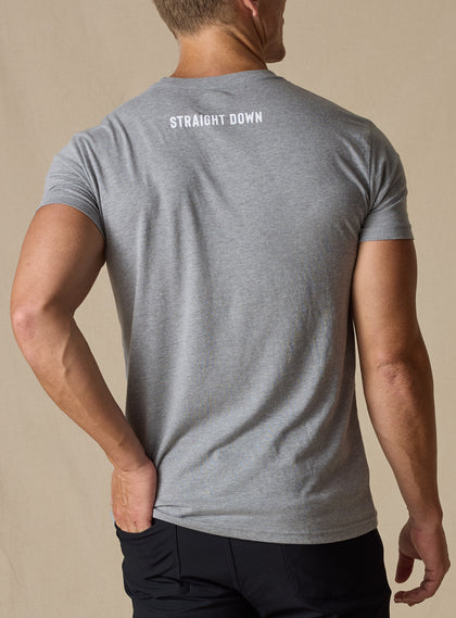 Men's USA Wings Tee in Heather, on model back view featuring a heather gray crewneck with a Straight Down wordmark at the upper back neck styled with black pants