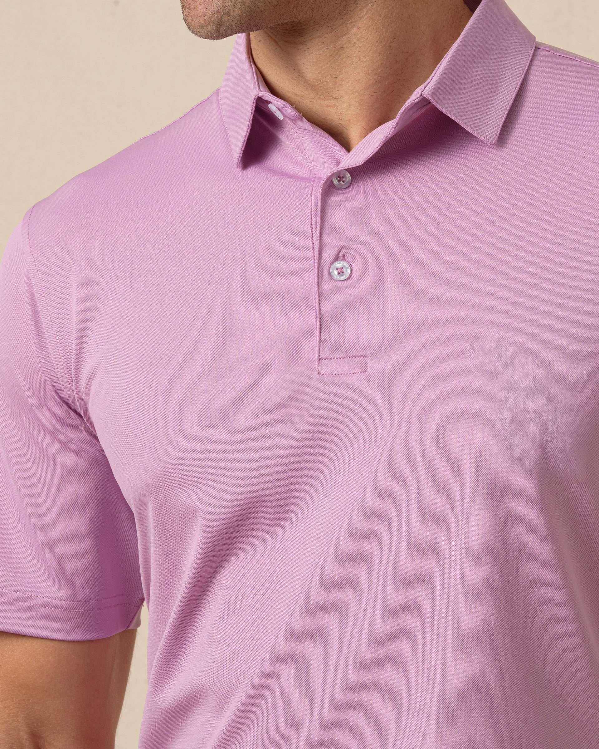 Close-up of men’s haze pink/purple polo shirt showing collar, and button placket