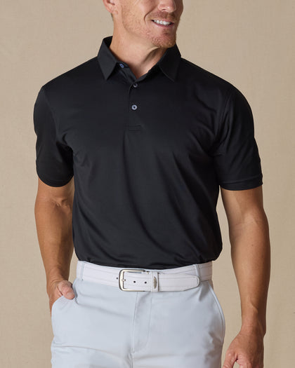 Men’s Sullivan Polo in Black styled with light gray golf pants, front view