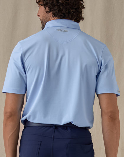 Men’s Sullivan Polo in Carolina Blue, back view worn with navy golf pants