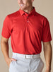 Men’s Sullivan Polo in Flag Red styled with light gray pants, front view