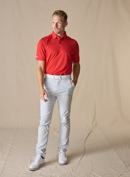 Full-body view of the Sullivan Polo in Flag Red paired with light gray pants