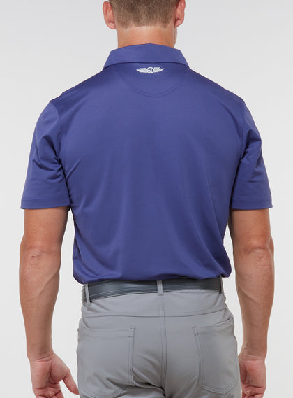 Men’s Sullivan Polo in skipper blue, back view worn with gray golf pants