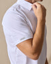 Close-up of the Sullivan Polo in white featuring lightweight performance fabric and sleeve logo detail