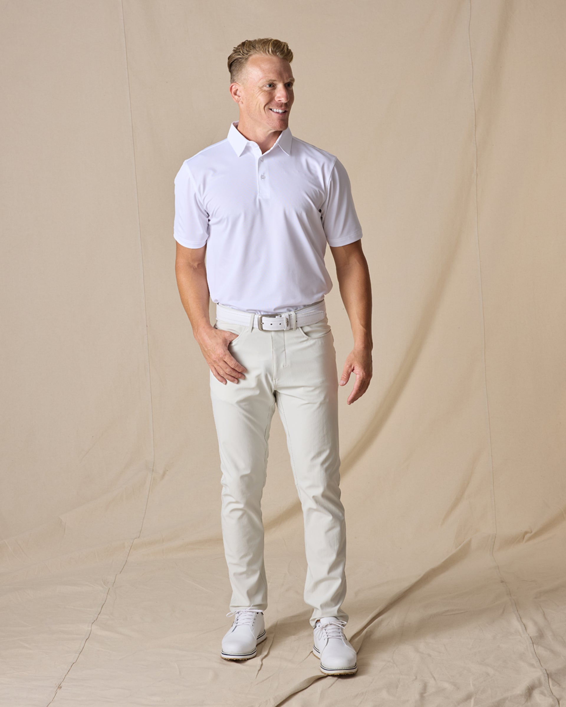 Full-body view of the Sullivan Polo in white styled with light golf pants and white golf shoes
