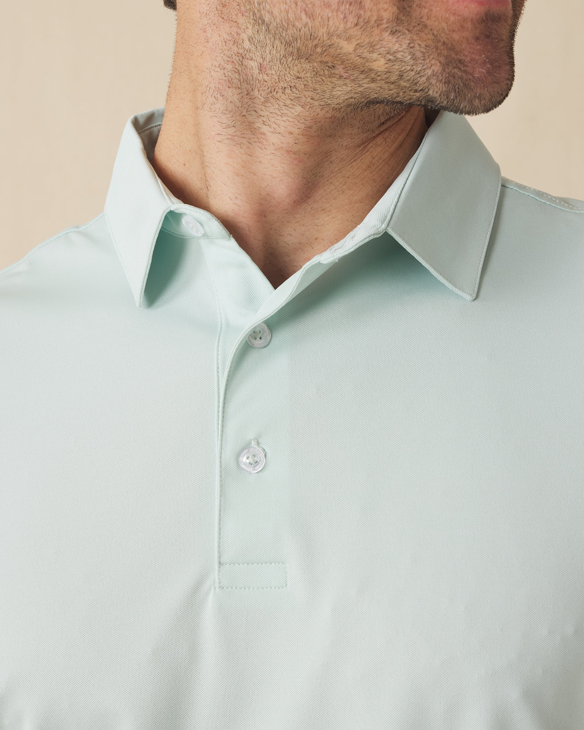 Close-up of the Sullivan Polo collar and placket in celery green