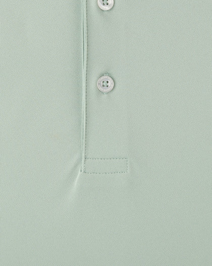 Close-up of light green golf polo fabric with button placket detail