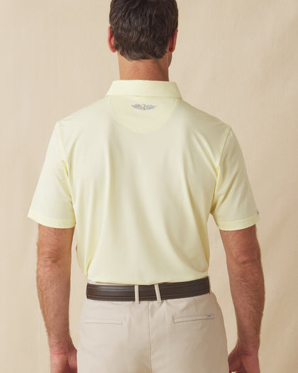 Men’s Sullivan Polo in pale yellow worn with khaki shorts, back view