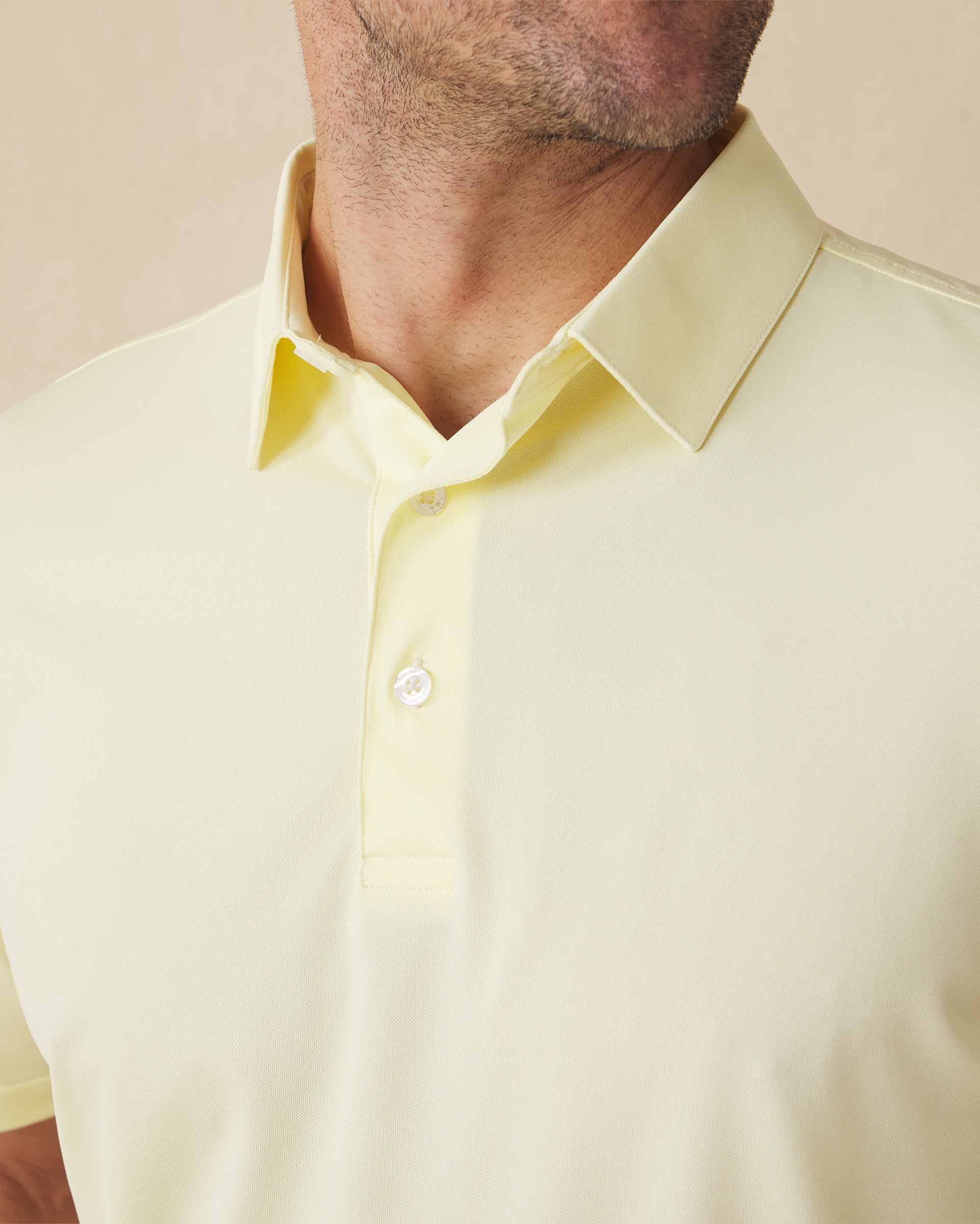 Close-up of the Sullivan Polo collar and placket in pale yellow