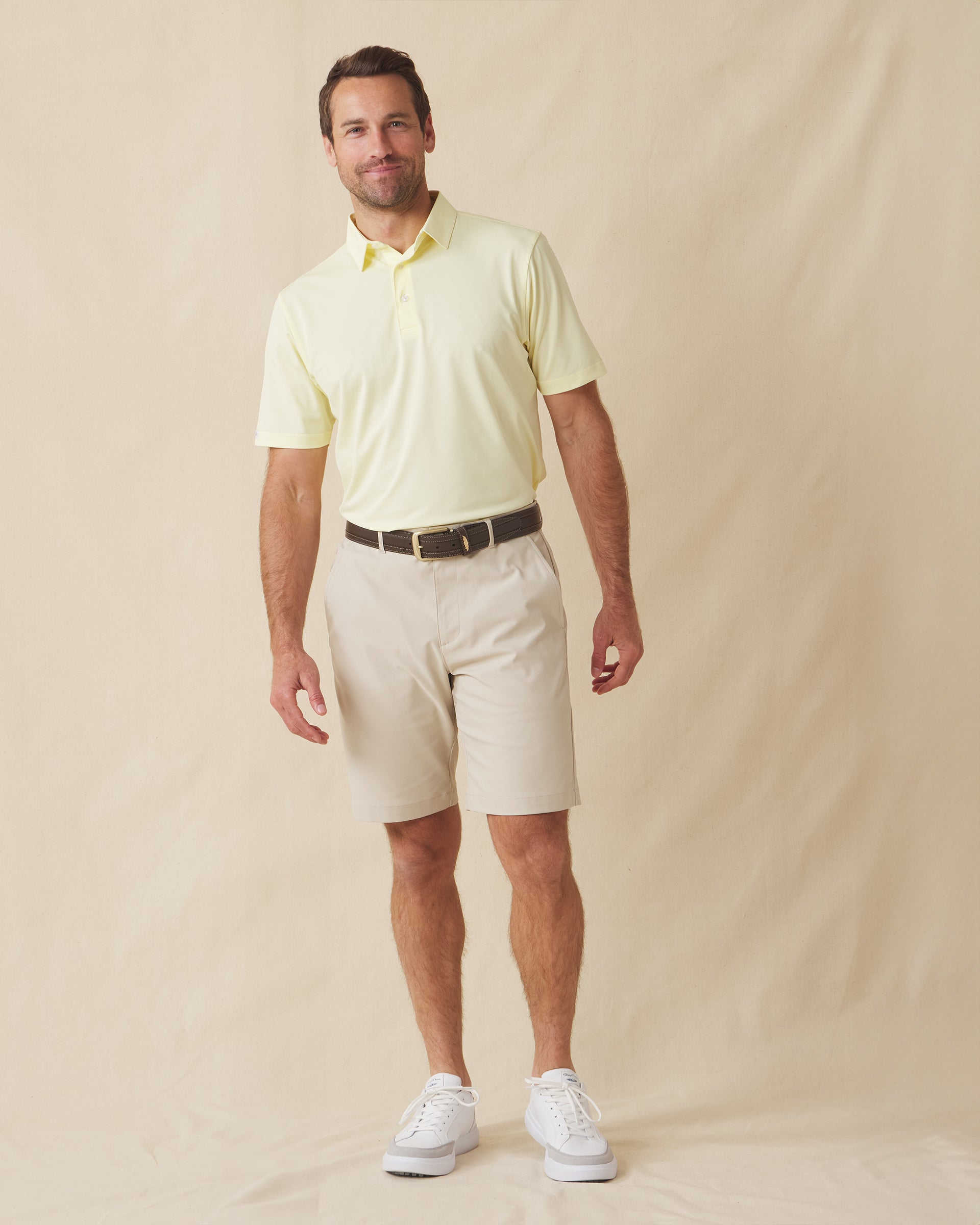Men’s Sullivan Polo in pale yellow worn with khaki shorts, full-body view
