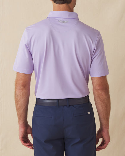 Men’s Sullivan Polo in violet worn with navy shorts, back view
