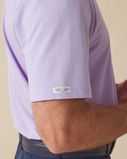 Close-up of the Sullivan Polo sleeve logo tab in violet