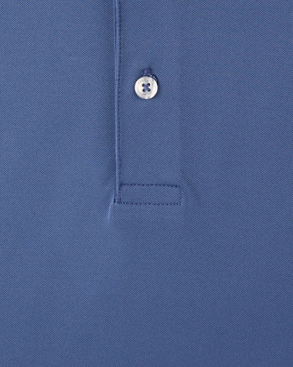 Close-up of a blue polo shirt showing the collar area with a single white button and a stitched pocket detail.