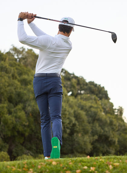 Stearns Long Sleeve Polo in White, golfer finishing swing back view on course 