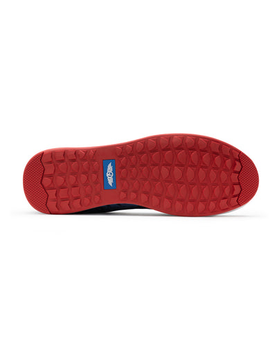 Men's Field V2 Shoe in Camo Indigo, bottom sole view featuring a red rubber outsole with multi-directional traction lugs and a blue branded logo badge